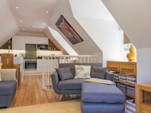 a living room with a couch and a kitchen at The Manor Coach House in Chilham