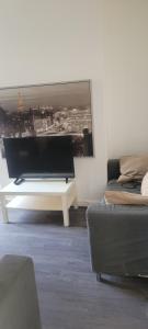 ein Wohnzimmer mit einem TV und einem Sofa in der Unterkunft 18 Decent Homes in Manchester
