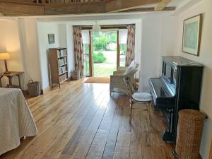 a living room with a tv and a wooden floor at North Barn in Tolpuddle
