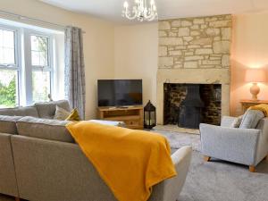 un soggiorno con divano e camino di Sheilas Cottage a Christon Bank