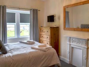 una camera da letto con un letto e due asciugamani di Sheilas Cottage a Christon Bank