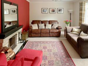 a living room with a couch and a fireplace at Torr Caladh in Glenfinnan