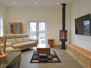 a living room with a couch and a fire place at Stambar in Llanglydwen