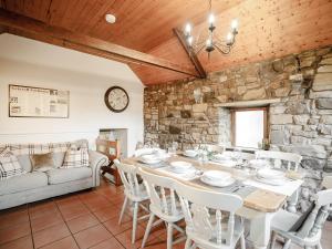 a dining room with a table and a stone wall at Well House in Belford