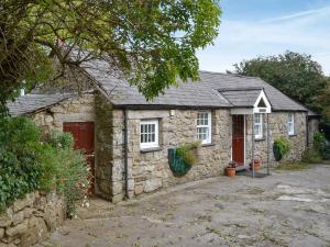 a stone house with a red door at Pant Y Mel in Brynteg
