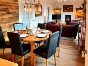 uma sala de jantar com uma mesa de madeira e cadeiras em Ratagan Lodge em Kintail