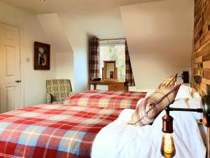 a bedroom with a bed with a plaid blanket at Ratagan Lodge in Kintail