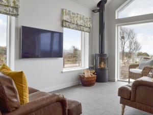 sala de estar con chimenea y TV en Muirtown Lodge, en Newmill