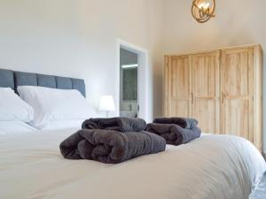 Una cama con toallas encima. en Muirtown Lodge, en Newmill