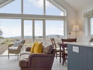 sala de estar con mesa, sillas y ventanas en Muirtown Lodge, en Newmill