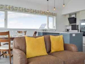 a couch with two yellow pillows in a kitchen at Muirtown Lodge in Newmill