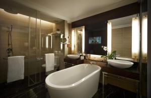 ein Badezimmer mit zwei Waschbecken und einer großen Badewanne in der Unterkunft The Majestic Hotel Kuala Lumpur, Autograph Collection in Kuala Lumpur