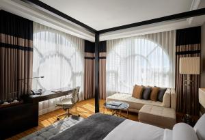 a bedroom with a bed and a desk and a couch at The Majestic Hotel Kuala Lumpur, Autograph Collection - TravelEase Visa-Free Getaway in Kuala Lumpur