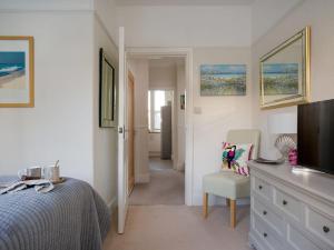 a bedroom with a bed and a tv and a chair at Kinbrae Apartment in Torquay