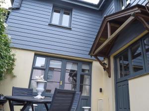 a blue house with a table and chairs at Shadycombe Lodge in Salcombe