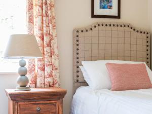 a bedroom with a bed and a lamp on a night stand at Glaisdale in Pickering