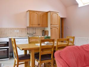 a kitchen with a wooden table and chairs in a kitchen at The Cottage At Cauldcoats in Linlithgow