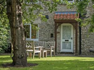a table and chairs in front of a stone house at Glaisdale in Pickering