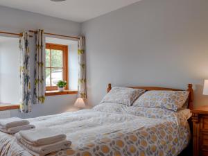 a bedroom with a bed with towels on it at The Cottage At Cauldcoats in Linlithgow