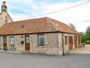 an old stone building with a red roof at The Cottage At Cauldcoats in Linlithgow