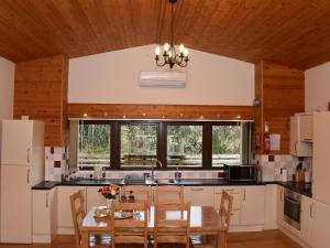 a kitchen with a wooden ceiling and a table and chairs at Ash Lodge - Hw7442 in Nantmel