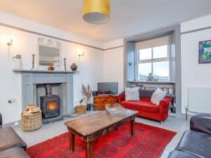 ein Wohnzimmer mit einem roten Sofa und einem Kamin in der Unterkunft Seafield House in Lochinver