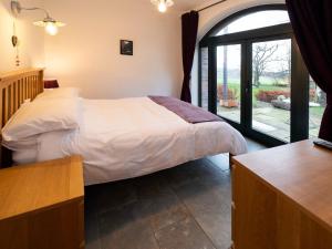a bedroom with a bed and a large window at Cart Shed in Mauchline