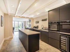 a large kitchen with black cabinets and appliances at Martineau House in Tynemouth