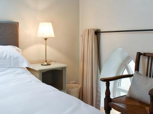 a bedroom with a bed and a lamp and a chair at The Old Chapel in Ashover