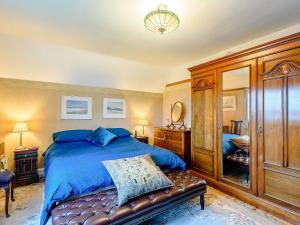 a bedroom with a bed with a blue comforter at Brandon in Sutton on Sea