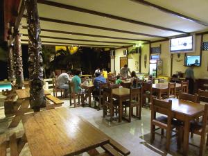 un restaurante con gente sentada en las mesas de un restaurante en Hotel El Murique, en Zorritos