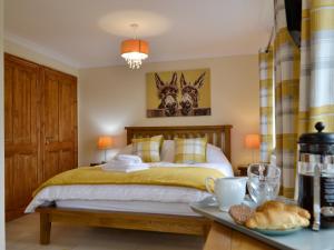 um quarto com uma cama e uma mesa com uma bandeja de pão em Marlais View em Llansadwrn