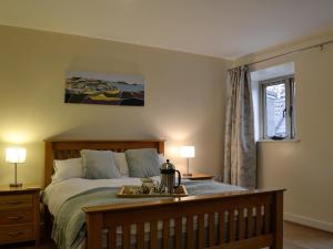 a bedroom with a bed with a tray on it at The Old Byre in Rhossili