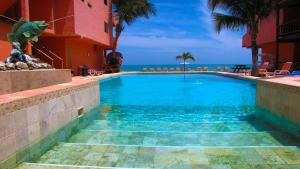 una piscina con el océano en el fondo en Hotel El Murique en Zorritos