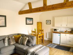 a living room with a couch and a kitchen at Gannet Lodge - Uk30977 in Bempton