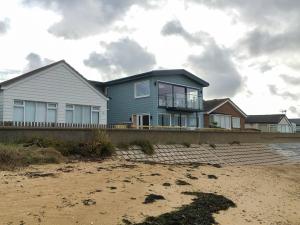 a house on the beach next to a beach at Curlew in Brightlingsea