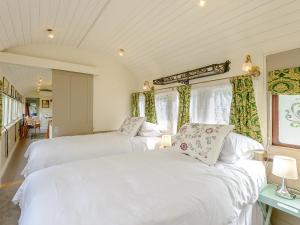 two white beds in a room with windows at Sprat Winkle in Horsebridge
