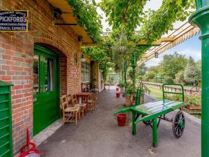 a brick building with a green table and chairs at Sprat Winkle in Horsebridge