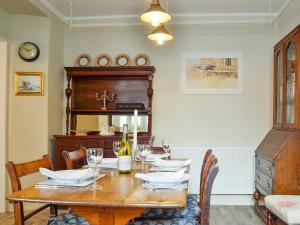 a dining room with a wooden table with wine glasses at The Mill House, The Square in Talgarth
