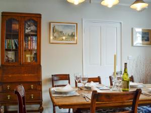 a dining room table with wine glasses and a cabinet at The Mill House, The Square in Talgarth