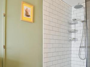 a bathroom with a shower with white tile at The Mill House, The Square in Talgarth