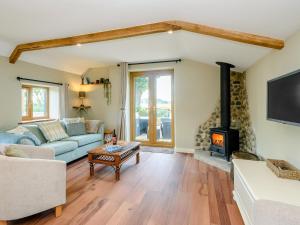 sala de estar con sofá y chimenea en Stackyard Cottage, en Felmingham