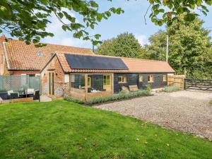 una casa con techo solar y patio en Stackyard Cottage, en Felmingham