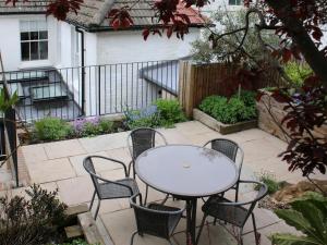 un patio con mesa y sillas en un jardín en Bay House en Hastings