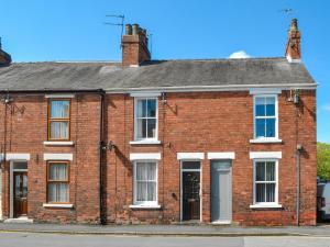 an old red brick building with white windows at Regent Cottage in Beverley