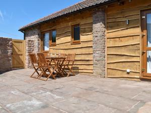 a patio with a table and chairs in front of a building at Cider Press Barn - Uk12379 in Lydney