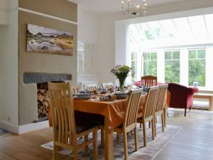 a dining room with a table with chairs and a fireplace at Trevene in Buttermere