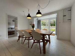 - une salle à manger avec une table et des chaises en bois dans l'établissement Lower Hilton Cottage, à Culrain