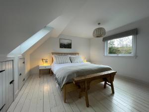 a bedroom with a large bed in a attic at Lower Hilton Cottage in Culrain