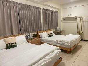 een slaapkamer met 2 bedden en een raam bij 埔里北梅民宿BEI MEI Homestay可包棟 in Puli